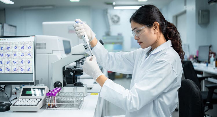 Researcher in lab using a pipetter.