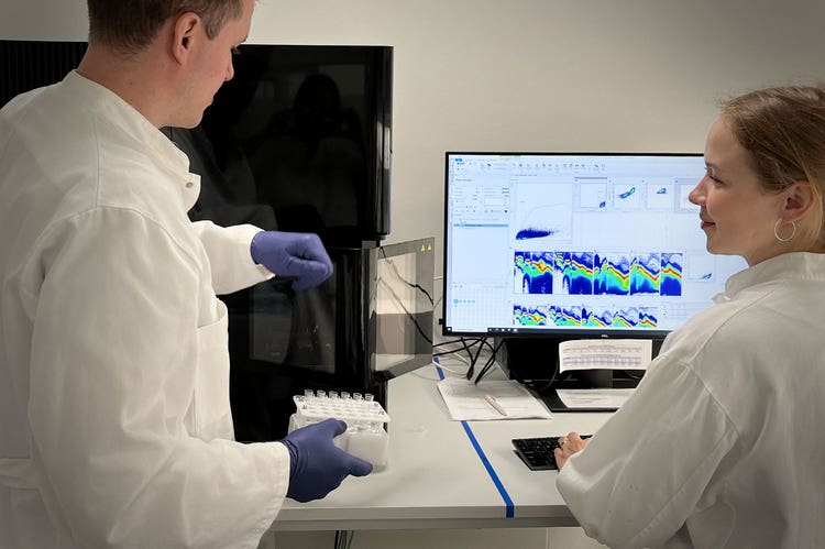 Two lab techs working with the ID7000 spectral cell analyzer.