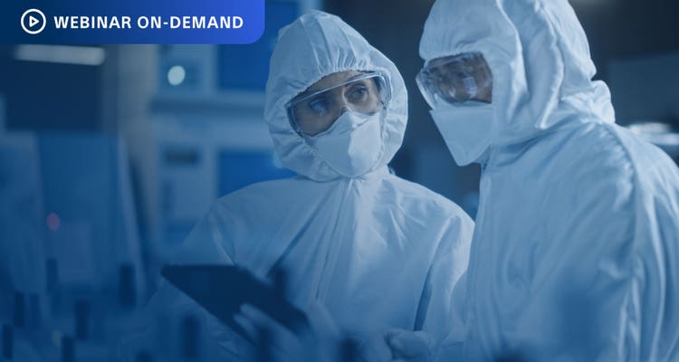 Webinar On-Demand. Two workers in clean suits looking at a tablet screen in a manufacturing setting.