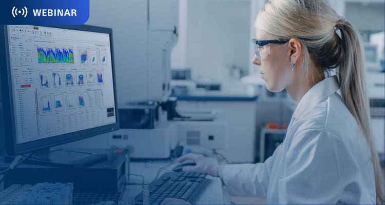 Researcher working in lab at a computer with spectral data on the display.
