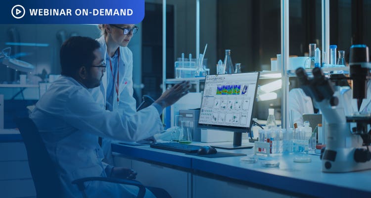 Webinar On-Deman. Two researchers in a dark lab looking at flow cytometry data on a computer display.