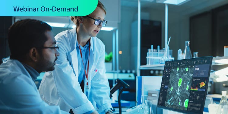 Webinar On-Demand. Photo of two researchers in a lab analyzing cancer cell data on a computer display.