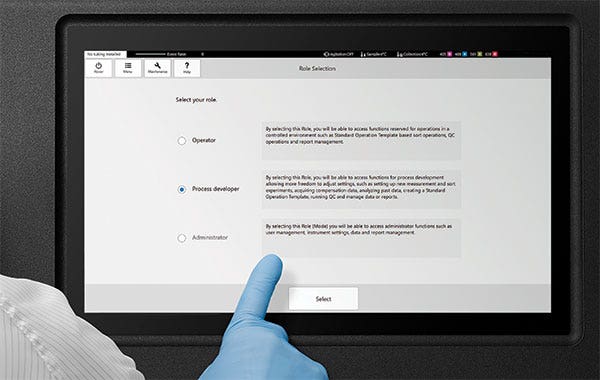 Researcher with gloved hand using touch screen to select a user mode.
