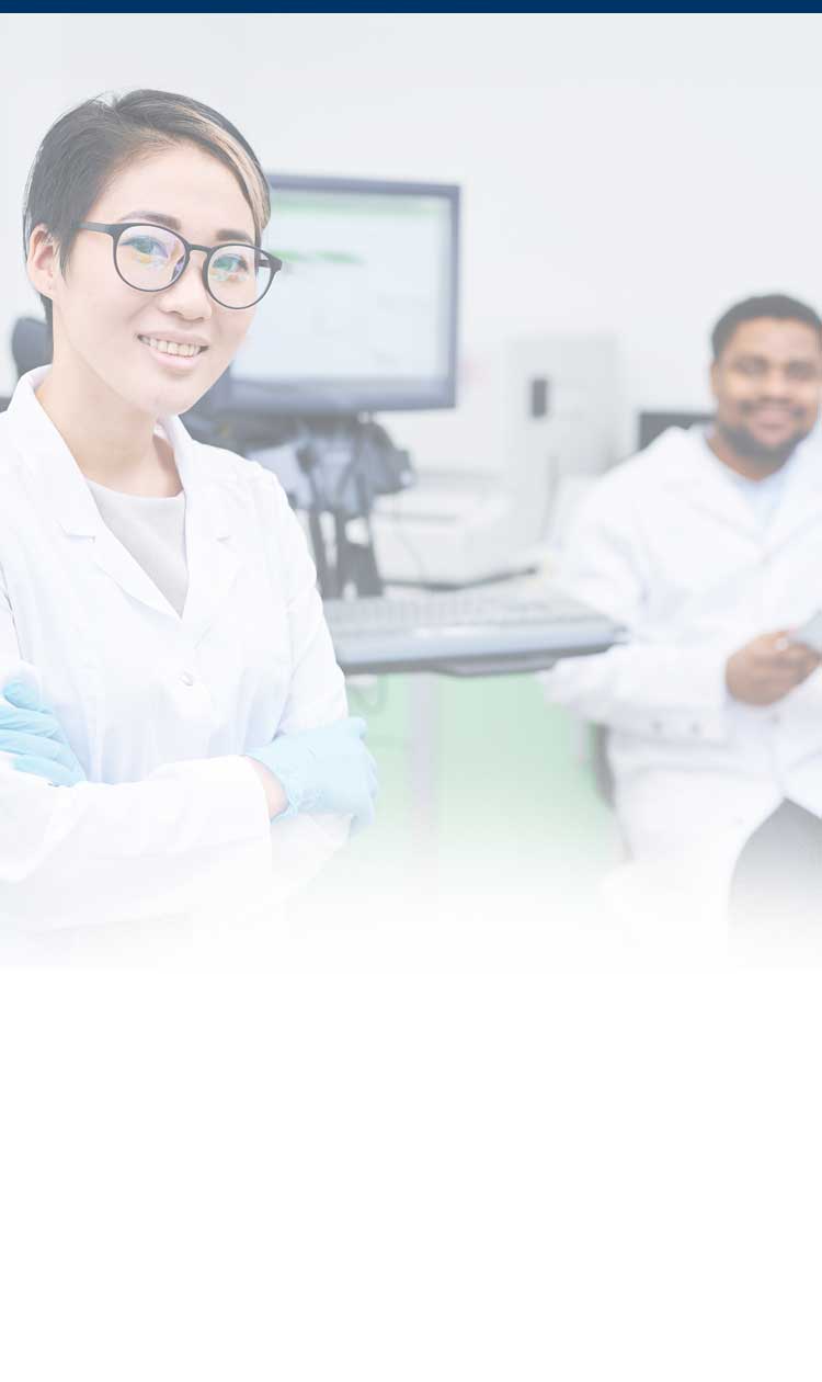 Researcher and colleague smiling in a lab setting.